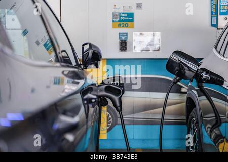 Hong Kong, Chine. 11 mars 2025. Deux véhicules électroniques rechargeables à la station Shell, l'une des plus grandes entreprises énergétiques au monde. Shell soupeserait les mérites d'une éventuelle reprise de son concurrent BP, suite à une chute brutale de la valeur marchande de BP. Bien qu’aucune offre formelle n’ait été faite, cette décision, si elle est poursuivie, pourrait remodeler le paysage énergétique mondial et faire l’objet d’un examen réglementaire intense. (Photo de May James/SOPA images/SIPA USA) crédit : SIPA USA/Alamy Live News Banque D'Images