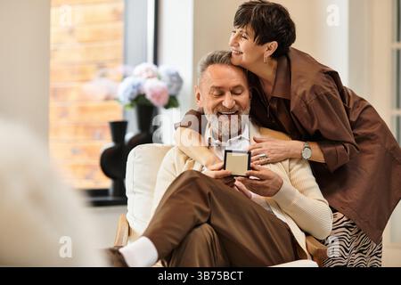 Un couple joyeux partage un moment tendre chez lui, entouré d’amour et de bonheur. Banque D'Images