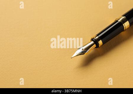 Un stylo plume sur fond jaune, gros plan. Espace pour le texte Banque D'Images