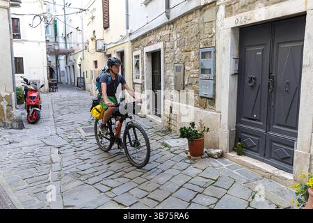 Touriste sur un voyage à vélo, bikepacking de Ljubljana à Piran en Slovénie, vélo dans les vieilles rues étroites pavées de la ville de piran, ville perlière de l'adriatique Banque D'Images