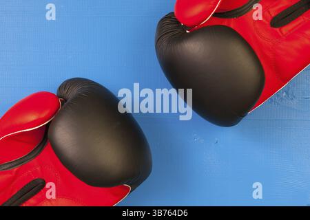 Gants de boxe rouges et noirs sur une table en bois bleu Banque D'Images