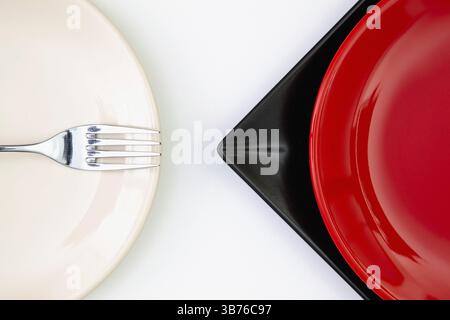 Différents rouges, noirs et plaques sur la table blanche. Vue de dessus. Image à plat Banque D'Images