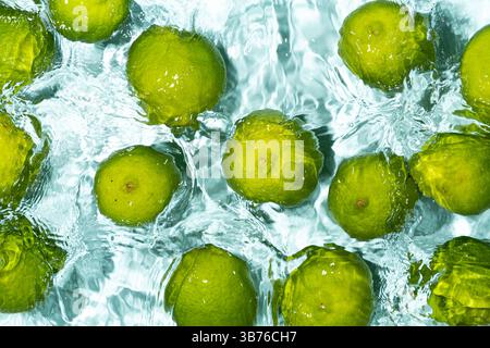 Limes vertes flottant sur fond d'eau calme. Banque D'Images