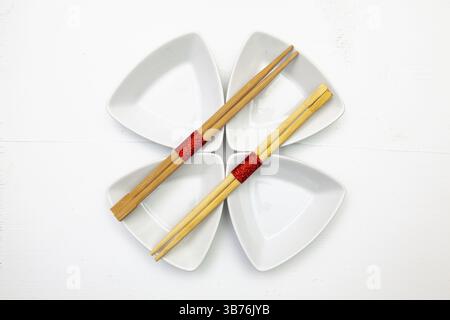 Bols en céramique et baguettes en bambou pour sushi avec décoration rouge et blanche Banque D'Images