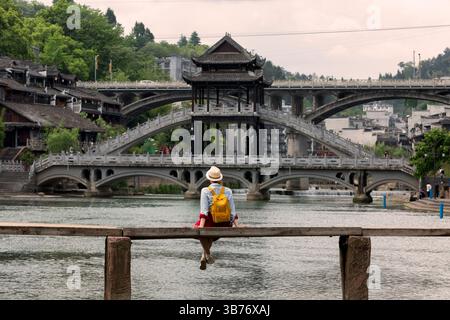 Jeune femme touriste regardant le beau paysage de la ville antique de Feng Huang, la célèbre destination touristique de la province du Hunan, en Chine Banque D'Images