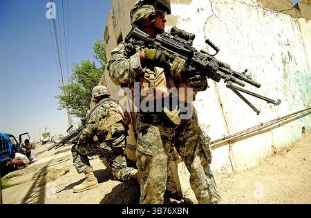 BATAILLE DE RAMADI 2006. Le Cpl Joseph Digirolamo du corps des Marines des États-Unis (à droite) assure la sécurité aérienne tout en cherchant à se protéger contre les tirs indirects d’armes légères lors d’une opération visant à prévenir et à perturber les activités insurrectionnelles à Ar Ramadi, en Irak, le 25 avril 2006. Digloramo est affecté en tant que correspondant de combat avec India Company, 3e bataillon, 8e Marines. Photo : US Marines Banque D'Images