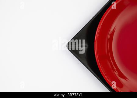 Différentes plaques rouges et noires sur la table blanche.vue de dessus. Image à plat Banque D'Images