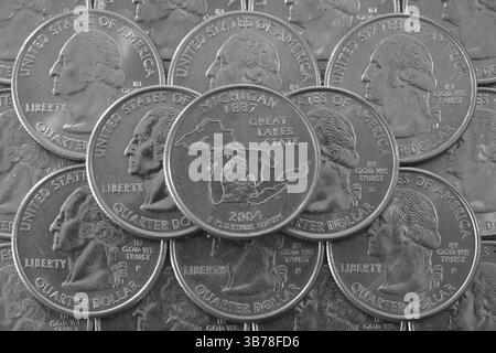 Pièces de monnaie des États-Unis. Pile des quarts de pièces US avec George Washington et sur le dessus un quart de Michigan State Banque D'Images