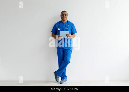 Sourire jeune Noir Docteur homme en uniforme avec presse-papiers dans les mains Banque D'Images