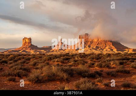 Coucher de soleil doré sur Monument Valley Buttes et paysage du désert Rouge avec des nuages spectaculaires Banque D'Images