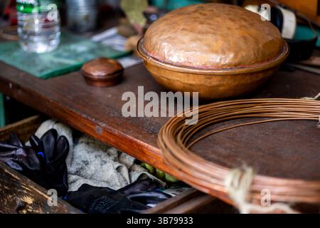 Établi d'un artisan ouvrier du cuivre qui fabrique toutes sortes d'ustensiles de maison avec du laiton et du cuivre. Banque D'Images