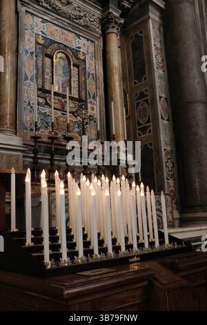 Rangées de bougies de dévotion blanches brûlantes dans la basilique Saint-Pierre symbolisant la prière, la réflexion spirituelle et la contemplation tranquille dans la Cité du Vatican. Photo de haute qualité Banque D'Images
