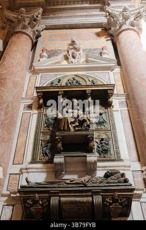 Monuments tombeaux baroques ornés à l'intérieur de la basilique Saint-Pierre, avec des sculptures dynamiques en marbre représentant des figures religieuses d'anges et des draperies symboliques sculptées dans un cadre architectural grandiose. Photo de haute qualité Banque D'Images
