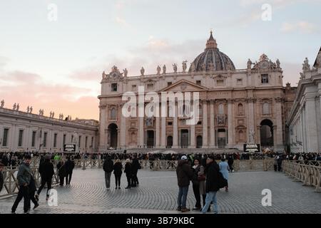 Place Saint Peters au coucher du soleil pendant la saison de Noël avec des foules d'arbres décorées de pèlerins et un ciel pastel doux autour des colonnades de la Cité du Vatican. Photo de haute qualité Banque D'Images