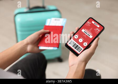 Touriste tenant téléphone portable avec e-ticket pour avion et passeport à l'intérieur, gros plan Banque D'Images