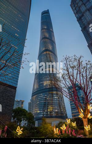 Shanghai, Chine – 1er avril 2025 : vue crépusculaire de la tour de Shanghai illuminée par le ciel crépusculaire avec des installations de papillons lumineux et une décoration florale Banque D'Images