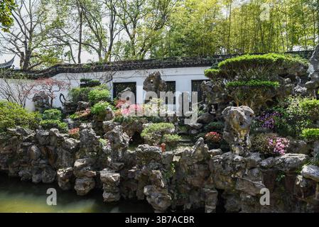 Shanghai, Chine - 1er avril 2025 : lac ornemental, rochers façonnés et arbres entretenus dans la conception paysagère classique du jardin Yuyuan, un site célèbre i. Banque D'Images