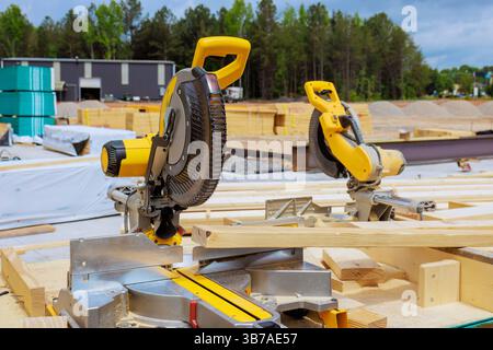 Les scies électriques sont prêtes sur le chantier de construction avec des outils de bois dispersés autour sous la journée de travail Banque D'Images