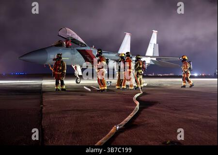 Les pompiers de l'US Air Force affectés au 18th civil Engineer Squadron réagissent à un tir simulé sur un F-15C Eagle lors d'un exer de préparation de routine Banque D'Images