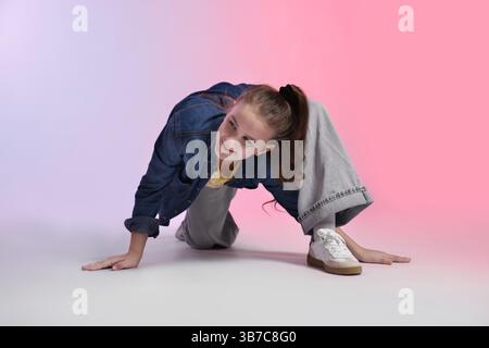Fille dans des vêtements élégants dansant sur fond de couleur Banque D'Images