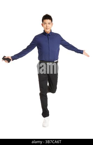 Homme d'affaires sautant dans les airs tout en tenant un smartphone. Banque D'Images