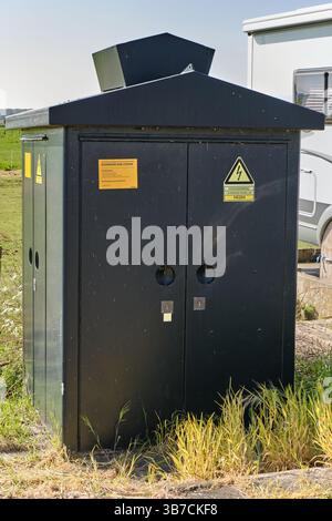 25 avril 2025 - Nieuwenhorn-pays-Bas : Station de transformation électrique Black Stedin avec panneaux d'avertissement haute tension debout dans une zone rurale près de A. Banque D'Images