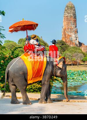 Thaïlande-Feb 09 2024 : les touristes prennent des excursions à dos d'éléphant, guidés par leurs gardiens, sur un après-midi chaud, près de l'ancien Palais Royal. Banque D'Images