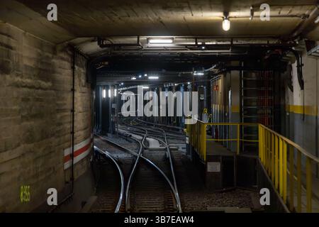 Tunnel ferroviaire souterrain à Berlin avec interrupteurs de voie complexes et éclairage industriel. Une vue cachée de l'infra technique du métro urbain Banque D'Images