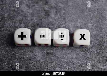 Symboles d'opération mathématique de base. Plus, moins, multipliez et divisez les symboles sur des cubes en bois ou des dés. Calcul de base pour le concept d'entreprise Banque D'Images