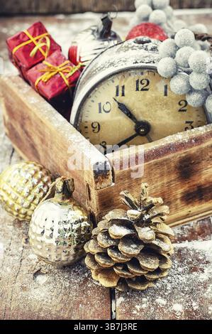 Boîte en bois élégant avec une horloge sur l'arrière-plan de cônes de pin Banque D'Images