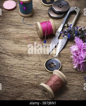 Ciseaux, fil et boutons sur fond de darianna non taillé dans un style vintage Banque D'Images