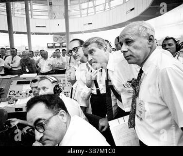 Wernher von Braun était un scientifique allemand. Pendant la seconde Guerre mondiale, lui et son équipe ont étudié et perfectionné la première fusée du monde (la V-2). À la fin de la guerre, ses connaissances ont été recherchées à la fois par l'URSS et les États-Unis. Von Braun se rendit aux Américains et il devint partie intégrante de leur programme spatial jusqu'à sa mort en 1977. Ici, il (2ème de R) regarde concentré dans un moment intense lors du lancement de la Saturn sa-6 dans la salle de tir. Sa-6 était le 6e lancement de Saturne avec un deuxième étage et une maquette de vaisseau spatial Apollo. À sa gauche se trouve le Dr George Mueller, et à l'extrême droite le Dr Eberhard Rees. Banque D'Images