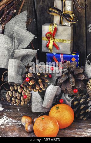 Composition d'hiver avec mandarines, pommes de pin et cadeaux Banque D'Images