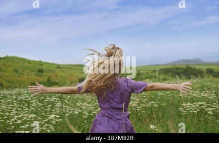 Vue arrière sur femme blonde heureuse avec les bras tendus appréciant la nature, USA, Amérique du Nord Banque D'Images