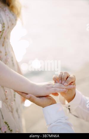 L'homme tient une main de femme avec une bague de fiançailles. Gros plan. Banque D'Images