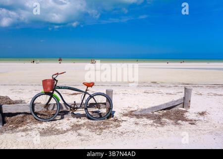 Holbox, Mexique – 10 février 2025 : un vélo de croisière classique avec un panier rouge se dresse sur le sable blanc immaculé d’Isla Holbox, face à la turquoise Banque D'Images