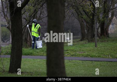24 avril 2020, Chicago, Illinois, États-Unis : un travailleur nettoie les ordures à Garfield Park dans le quartier West Garfield Park de Chicago le 24 avril 2020. Les ouvriers des rues et de l'assainissement de Chicago, du Département des eaux et de l'IDOT étaient occupés à tailler les branches des arbres, à peindre les bordures de rue et à appâter des rats avec du poison dans le quartier. (Crédit image : © Antonio Perez/Chicago Tribune via ZUMA Press Wire) Banque D'Images