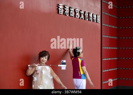 11 mai 2024, Hong Kong, CHINE : à Hong Kong, un nouveau spot touristique au HONG KONG PALACE MUSEUM, des femmes touristes de Chine continentale posent pour la caméra et prennent un selfie devant l'entrée du musée. L'OFFICE DU TOURISME de Hong Kong distribuera des coupons de 200 dollars de Hong Kong aux touristes de 8 nouvelles villes continentales incluses dans le PROGRAMME DE VISITES INDIVIDUELLES, dans l'espoir d'attirer plus de continentaux à Hong Kong. Toutefois, contrairement à ce que le Gouvernement de Hong Kong attend, la tendance touristique des Chinois continentaux a largement changé par rapport aux précédentes ' visites individuelles ' qui incluaient souvent des catégories de personnes ayant un pouvoir plus fort Banque D'Images