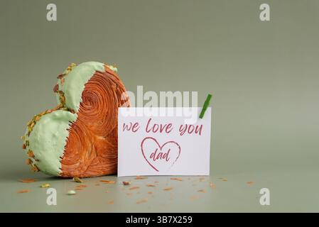 Carte de fête DES PÈRES délicieuse et vibrante pâtisserie en forme de coeur, agrémentée d'une abondance de noix glacées colorées. Espace de copie de modèle de maquette. Expérimentation alimentaire virale dessert tendance de cuisson créative Banque D'Images