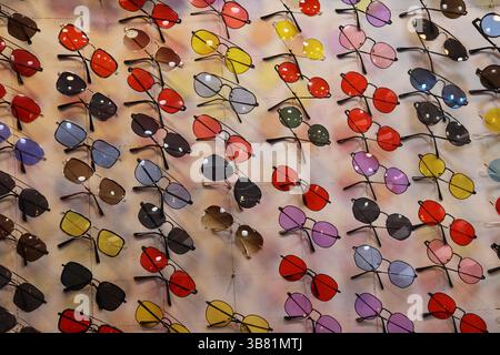Vue attrayante présente de nombreuses lunettes de soleil élégantes avec des verres dans des tons vibrants tels que rouge, jaune, violet, marron et bleu, tous élégamment di Banque D'Images