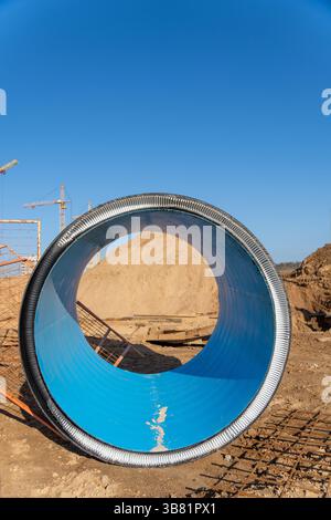 Un morceau de grand tuyau en plastique noir ondulé sur le chantier de construction. Tubes industriels en PVC. Il est utilisé pour la pose d'égouts pluviaux et d'égouts. Banque D'Images