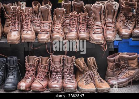 Bottes brunes de combat d'occasion exposées au marché du dimanche de Brick Lane à Londres, en Angleterre Banque D'Images