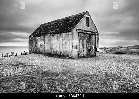 La maison abandonnée du bateau de sauvetage Mary Stanford dans la réserve naturelle de Rye Harbour, Winchelsea, représentée dans un ton noir et blanc très contrasté Banque D'Images