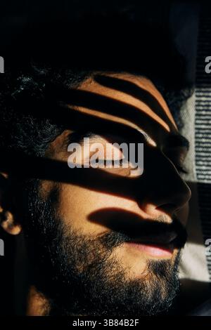 La lumière du soleil brille sur le visage de l'homme dormant à la maison Banque D'Images