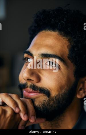 Gros plan d'un homme souriant avec la main sur le menton Banque D'Images