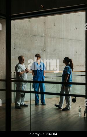 Infirmières écoutant un médecin expliquant en se tenant debout dans le couloir hospitalier Banque D'Images