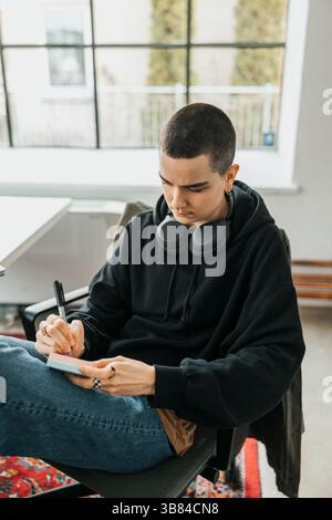 Vue à angle élevé des idées d'écriture professionnelles INFORMATIQUES non binaires sur des notes adhésives tout en étant assis dans le bureau Banque D'Images