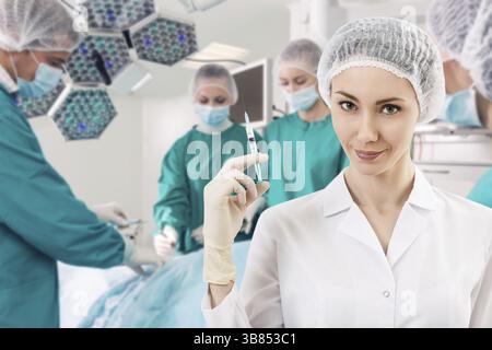 Jeune femme anesthésiste avec seringue sur l'arrière-plan teem chirurgie Banque D'Images
