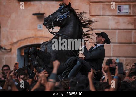 23 juin 2024, Ciutadella de Menorca, Îles Baléares, Espagne : un 'caixer' (cavalier) se lève sur son cheval entouré d'une foule enthousiaste pendant le 'Caragol des Born' (défilé équestre) à la veille du traditionnel 'Sant Joan' (Saint Jean) festival. (Crédit image : © Matthias Oesterle/ZUMA Press Wire) Banque D'Images