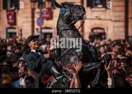 23 juin 2024, Ciutadella de Menorca, Îles Baléares, Espagne : un 'caixer' (cavalier) se lève sur son cheval entouré d'une foule enthousiaste pendant le 'Caragol des Born' (défilé équestre) à la veille du traditionnel 'Sant Joan' (Saint Jean) festival. (Crédit image : © Matthias Oesterle/ZUMA Press Wire) Banque D'Images